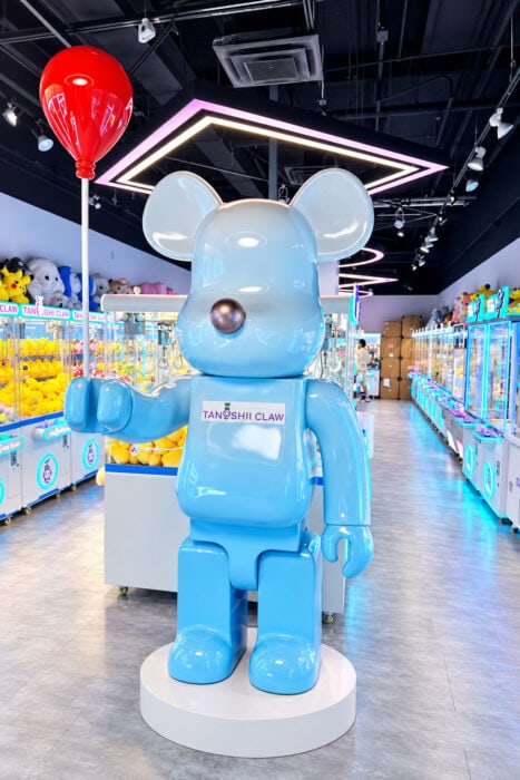 Glossy Blue Mascot In Neon Claw Arcade